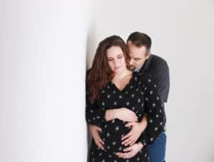 Married couple hugging pregnant belly