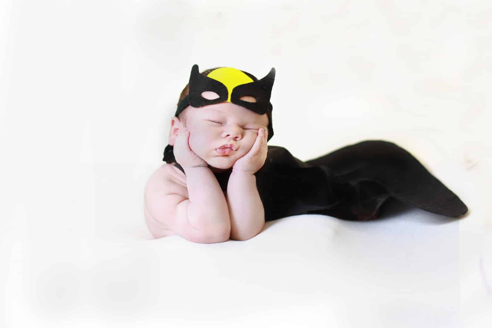 Sleeping newborn baby in a superhero suit