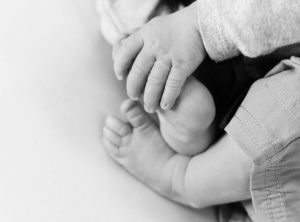 black and white images with newborn feel, hand grabbing foot