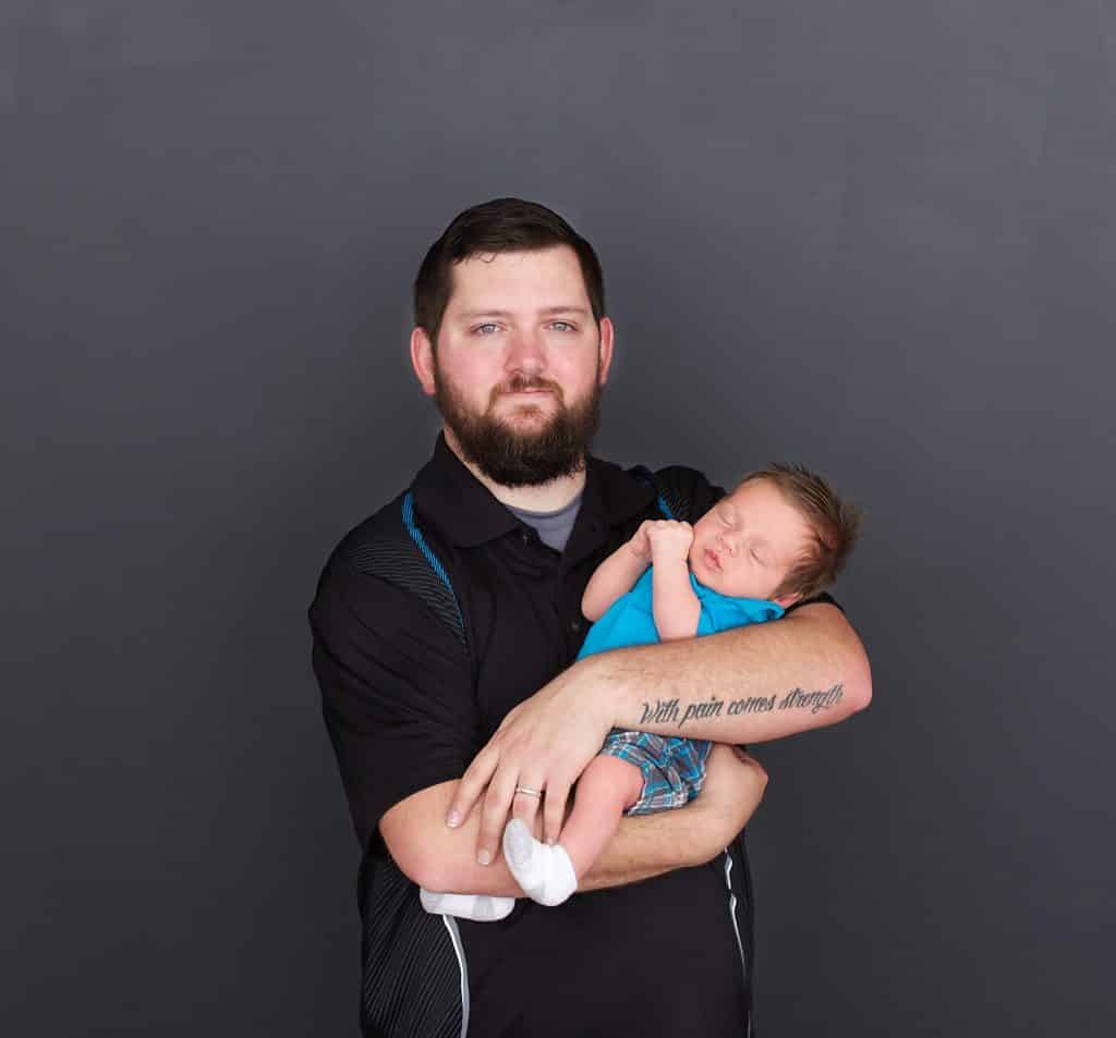 new dad, black background, newborn sleeping