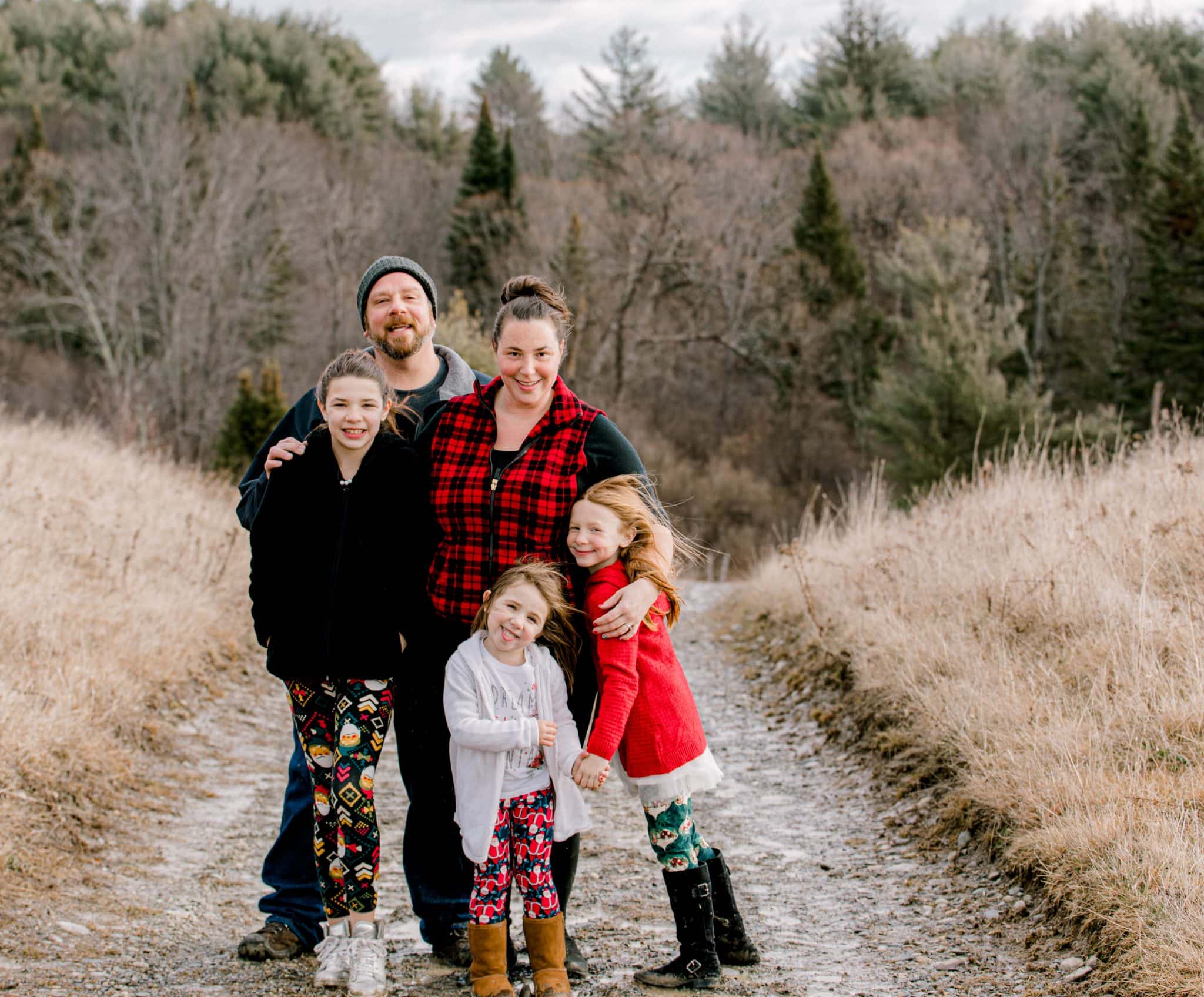 Family photo wearing red and black, open field, all smiling and looking at the camera, silly faces