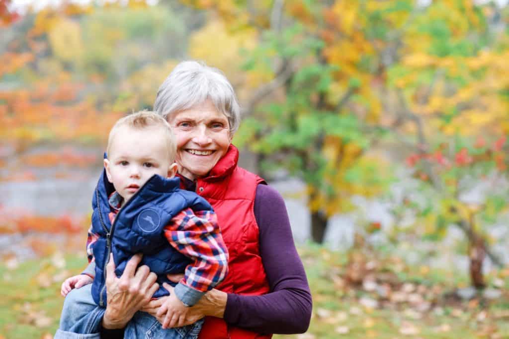 Grandmother with her grandson in the fall looking at the camera