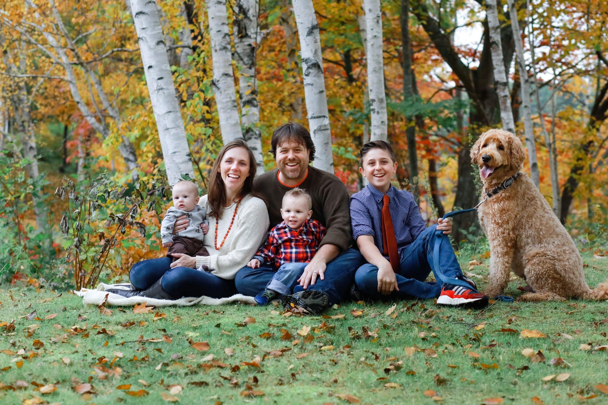 family looking at the photo in the fall with the dog in Bangor Maine