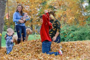 family playing in the leaves 