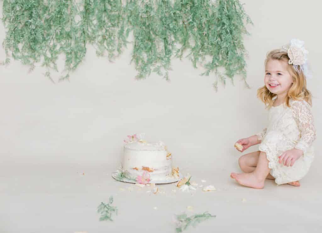 first birthday photoshoot girl eating cake 