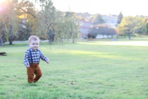 Little brother running in the grass near the augusta, Maine capitol