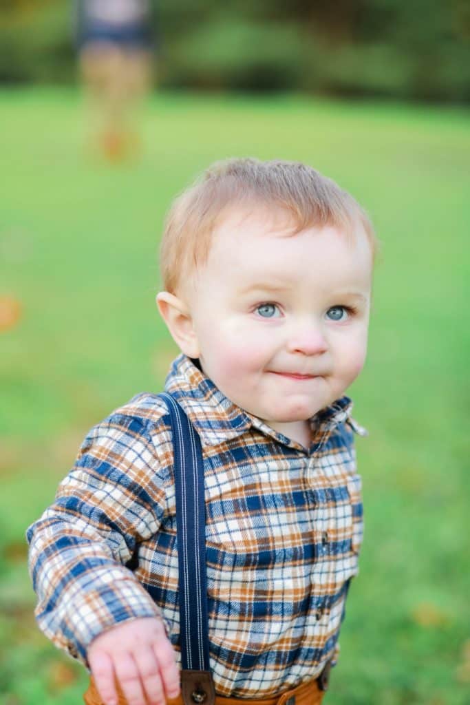 little brother running in the park with a smile