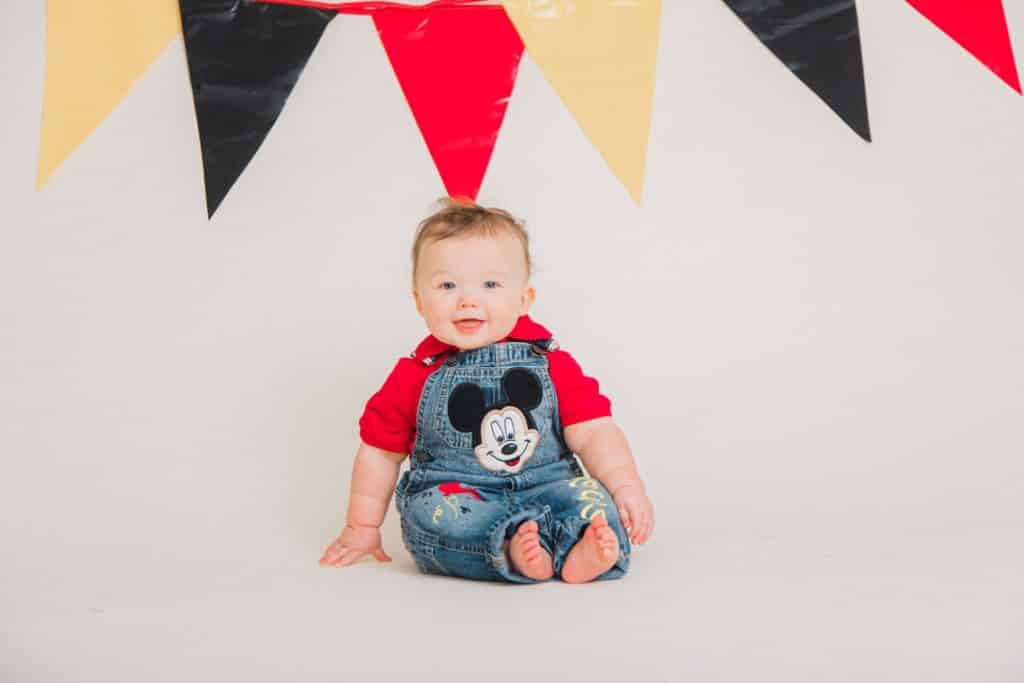 red, white, black banner, one year old smiling at the camera