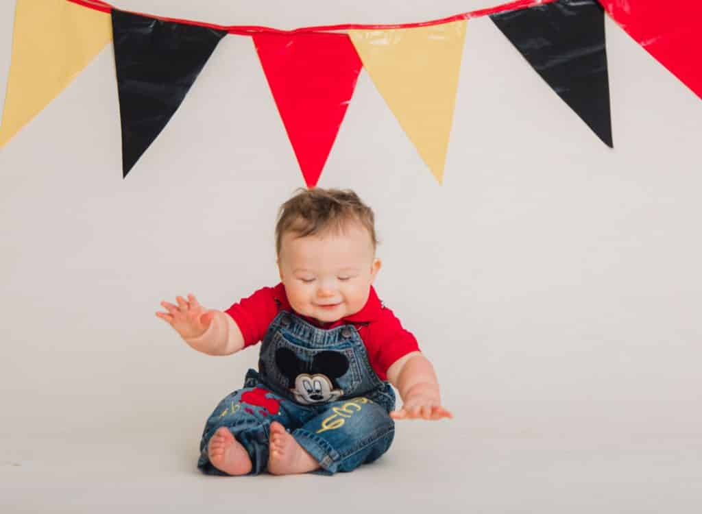 red, black, yellow, banner with one year old laughting