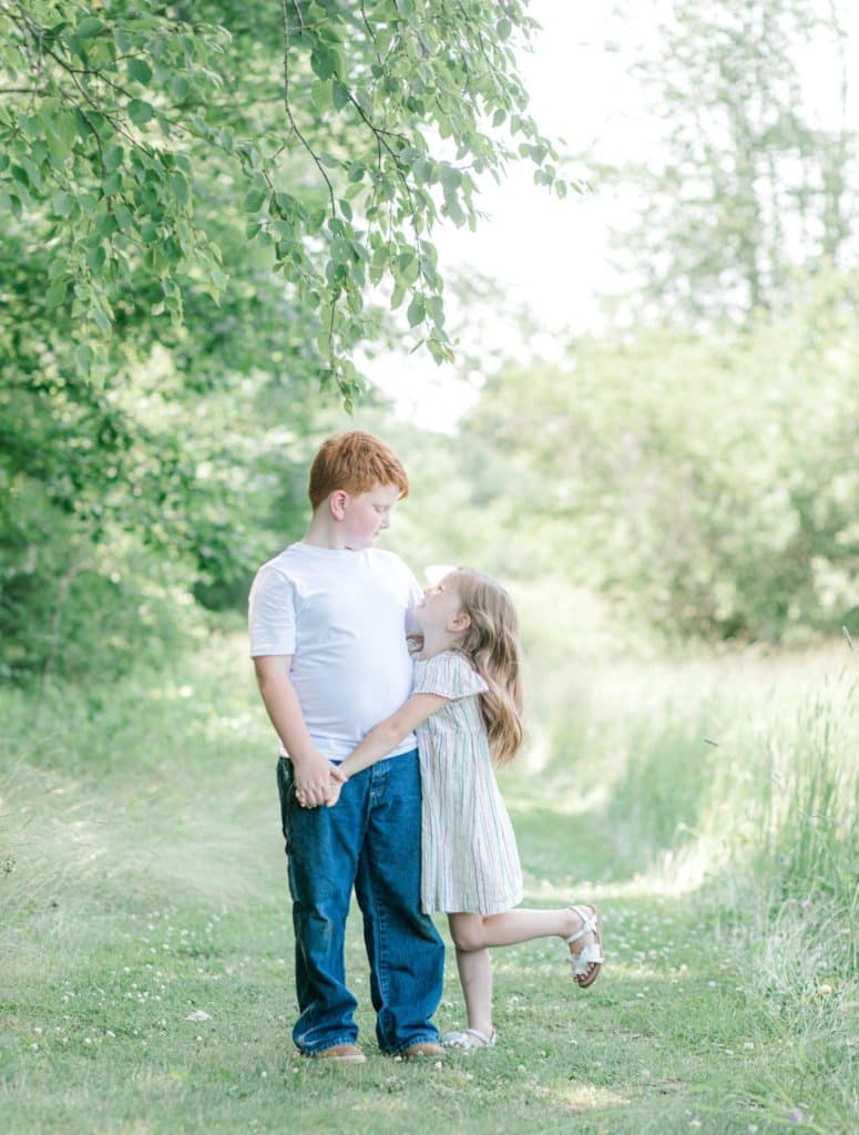 brother hugging sister, sister looking up at him