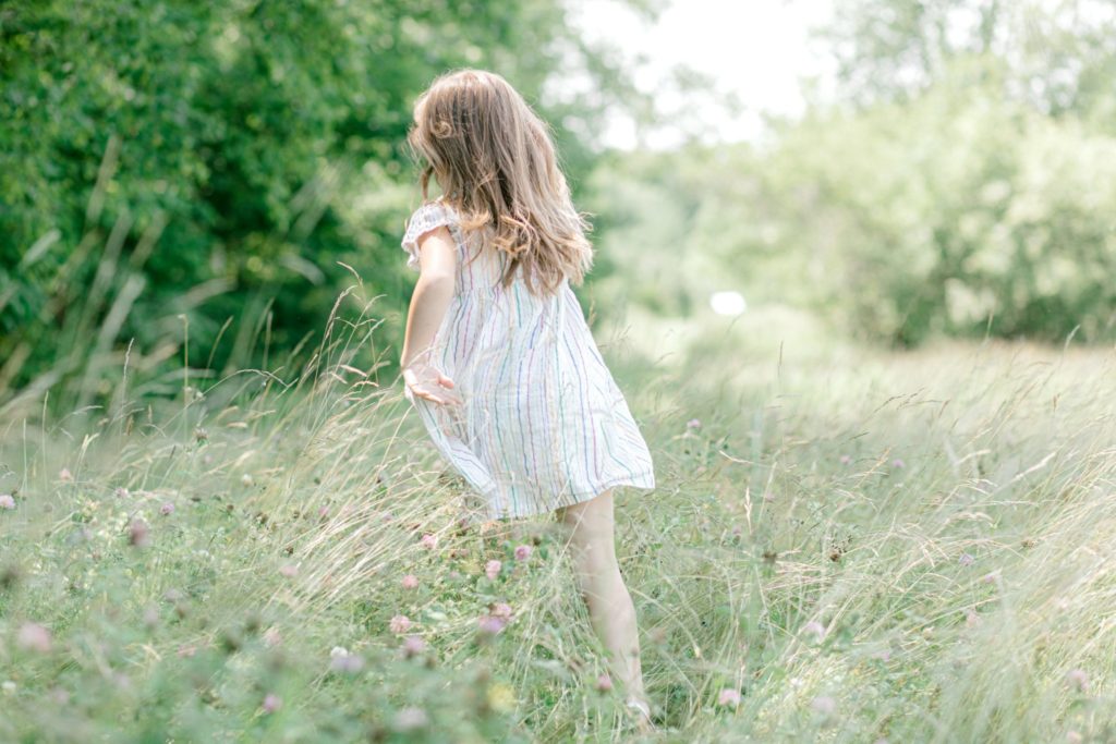 little girl running through tall grass