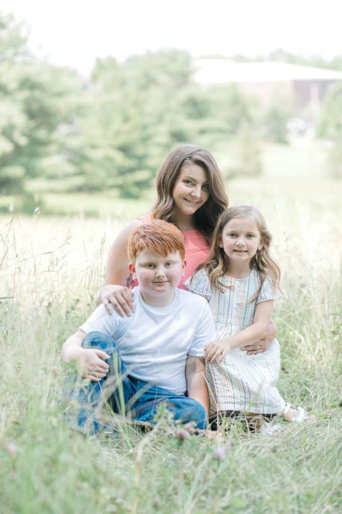 mother and two kids sitting down looking at the camera