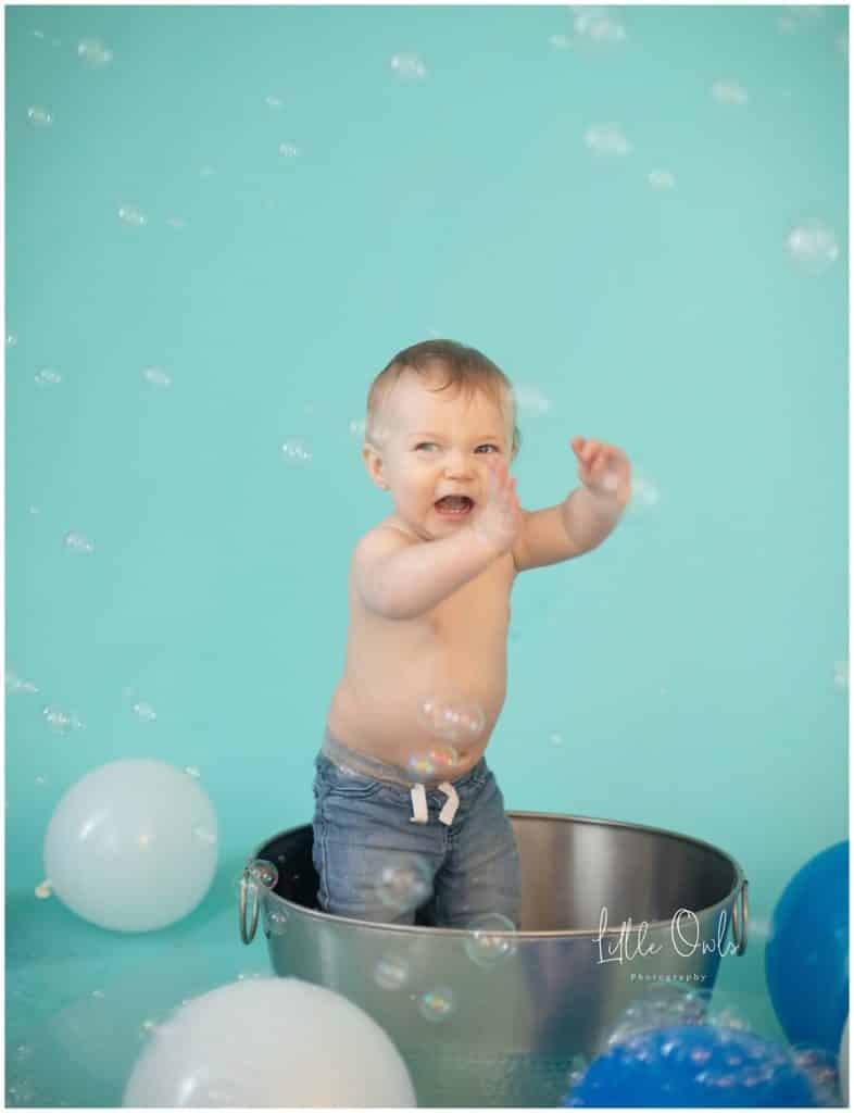 one year old hand up smiling with bubbles