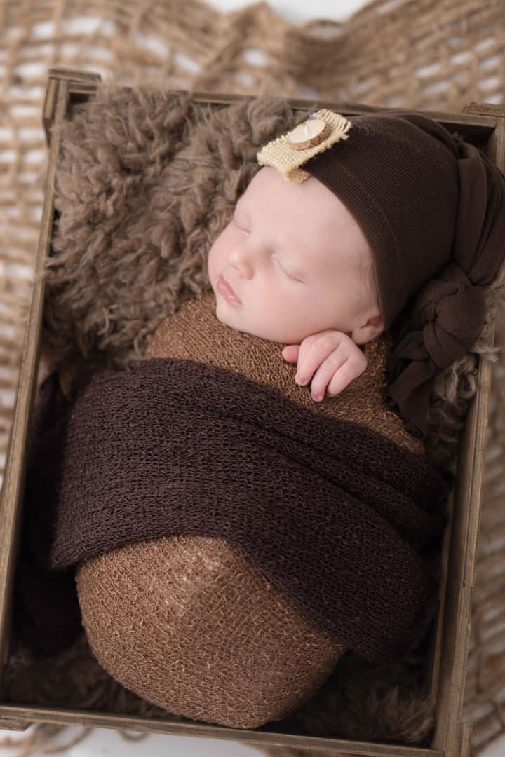 baby in a basket asleep in maine photo studio