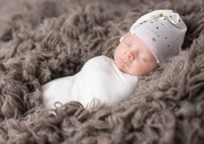 baby sleeping in fluffy brown blanket