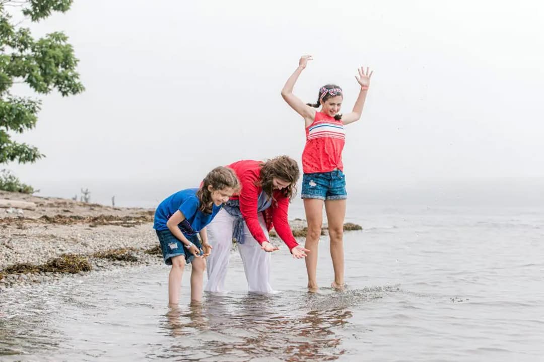 Family playing in water at maine beach