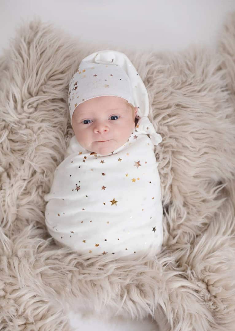 happy-baby eyes open newborn getting a photo shoot done in maine