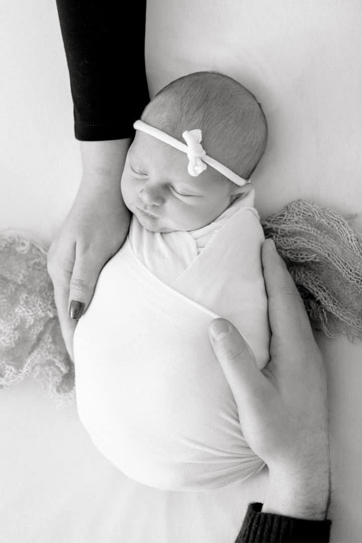 newborn picture caressed by two hands