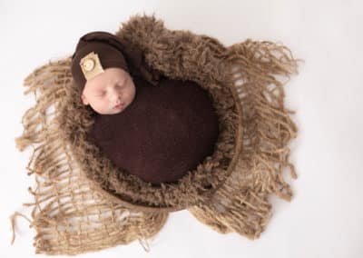 maine newborn sleeping wrapped in a blanket