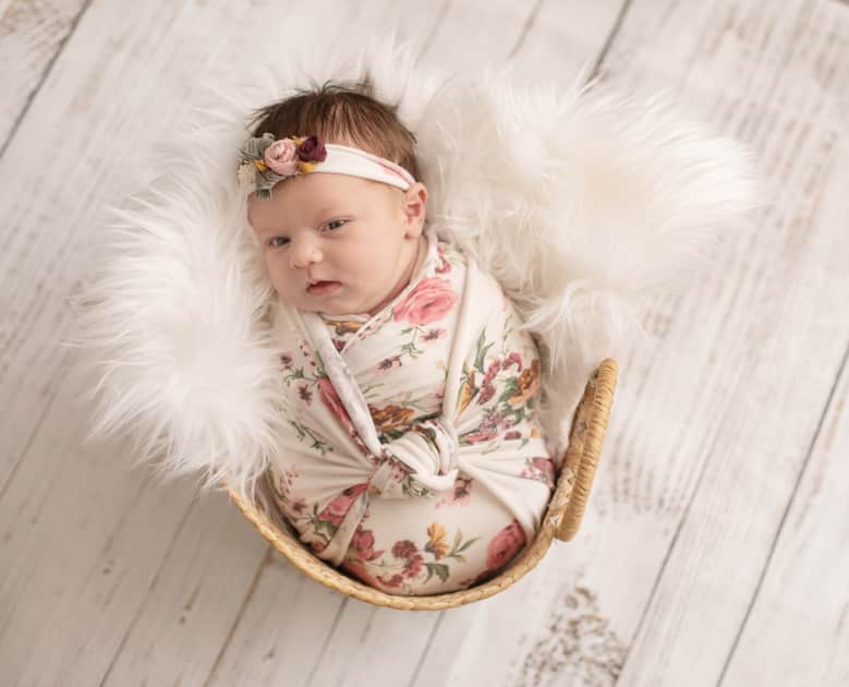 Newborn girl in basket swaddled up