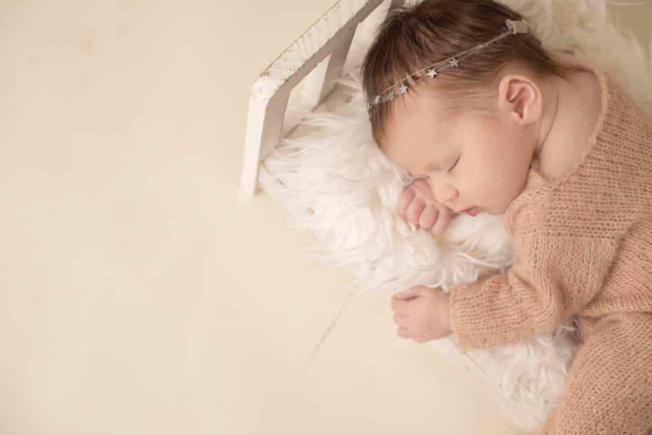 baby photographer in maine, posed newborn in baby crib, augusta maine studio