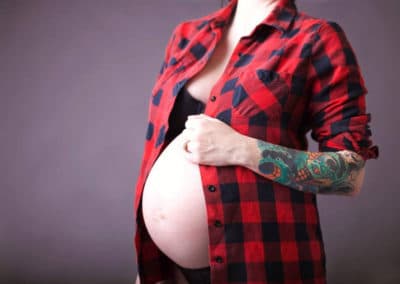 in studio maternity session in maine with mom wearing nothing but a plaid flannel shirt