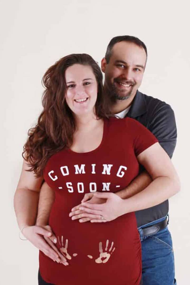 in studio maternity session in Maine husband and wife caressing baby bump